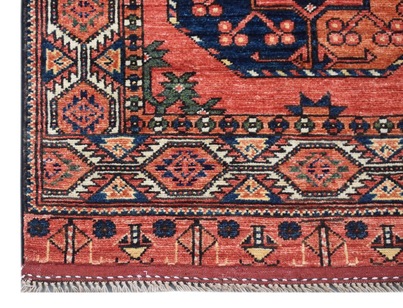 A handmade Afghan Chobi runner featuring traditional geometric patterns in red, blue, and tan.