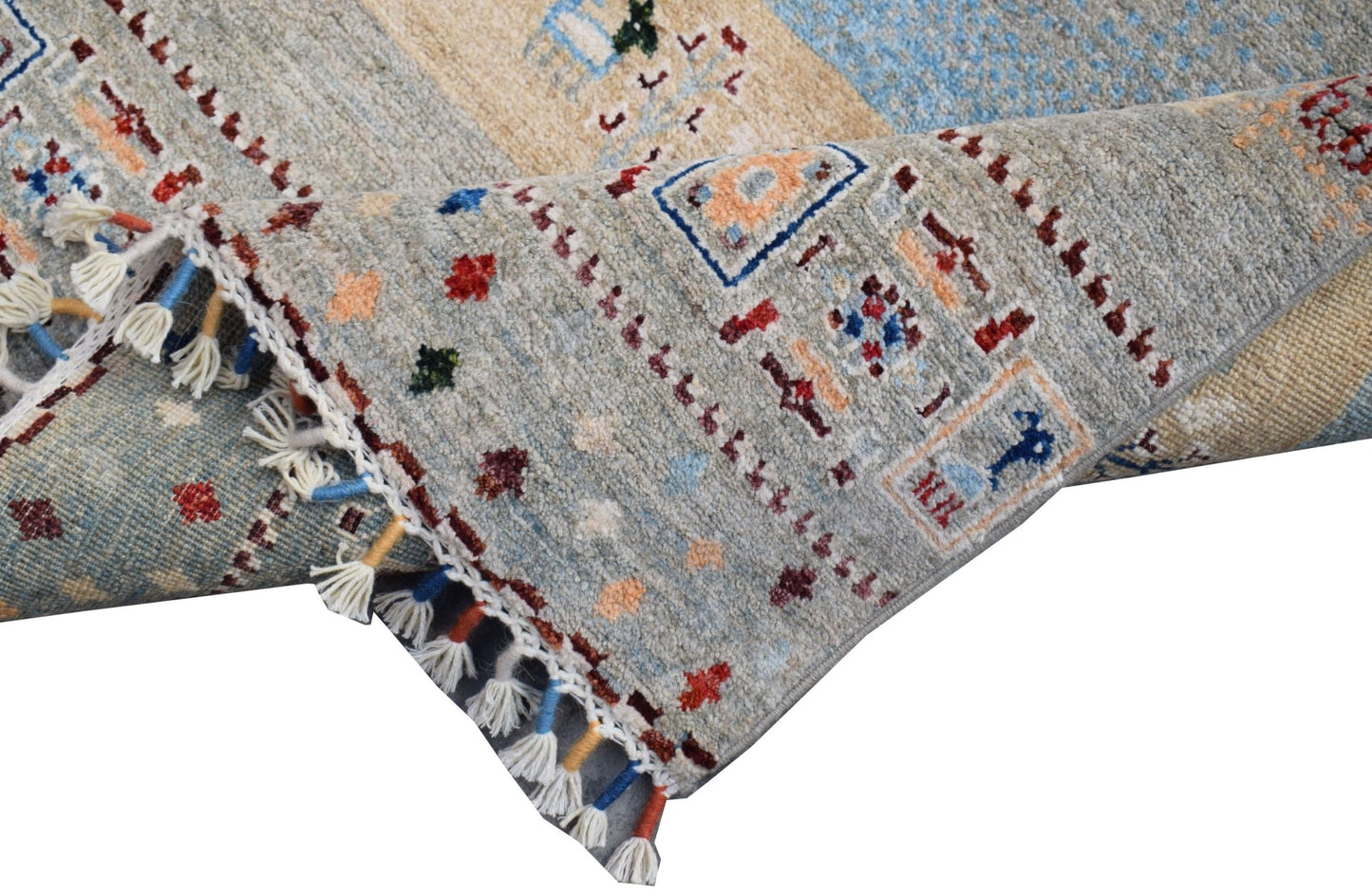 A handmade Afghan Chobi runner featuring a light blue and beige pattern with decorative tassels.