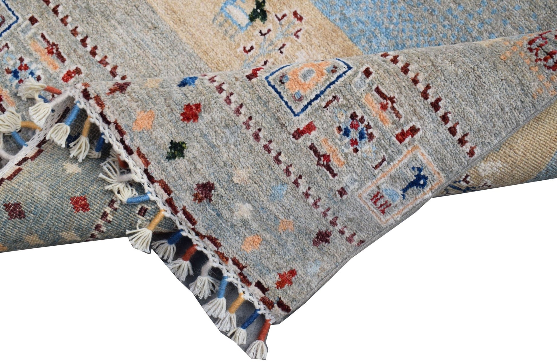 A handmade Afghan Chobi runner featuring a light blue and beige pattern with decorative tassels.