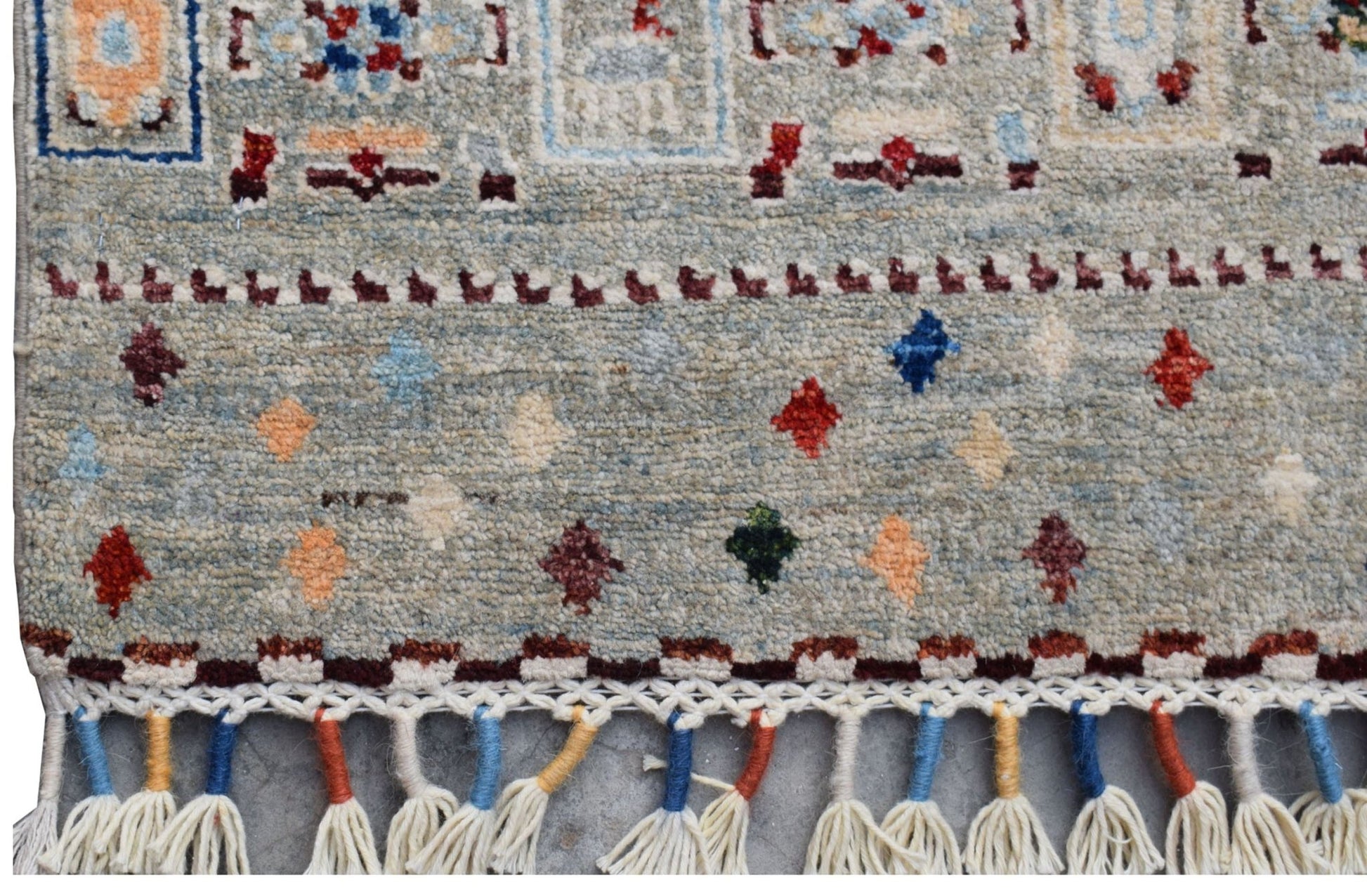 A handmade Afghan Chobi runner featuring a light blue field with colorful geometric motifs.