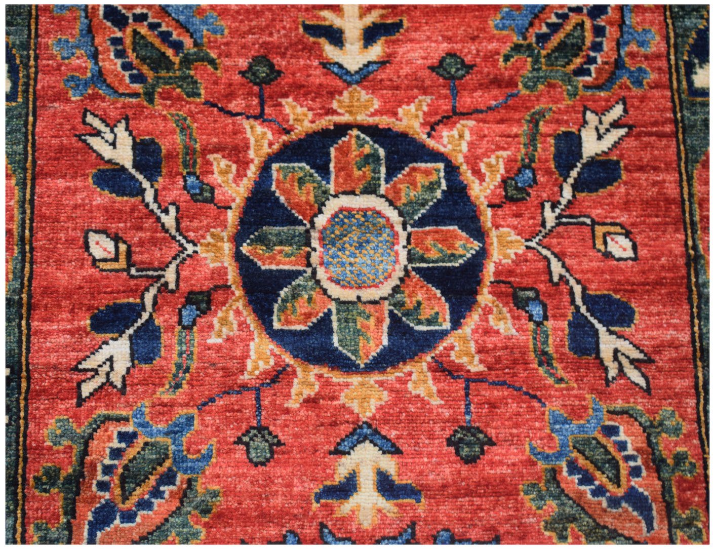 An Afghan Chobi runner featuring a central floral medallion on a red field with blue accents.