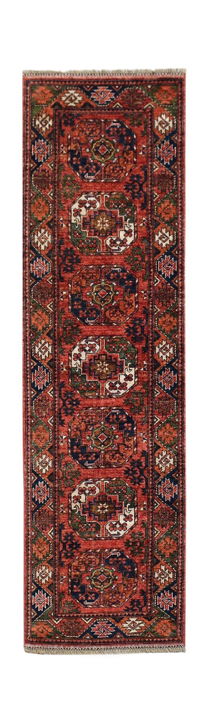 A handmade Afghan Chobi runner rug featuring a repeating geometric medallion pattern in red.