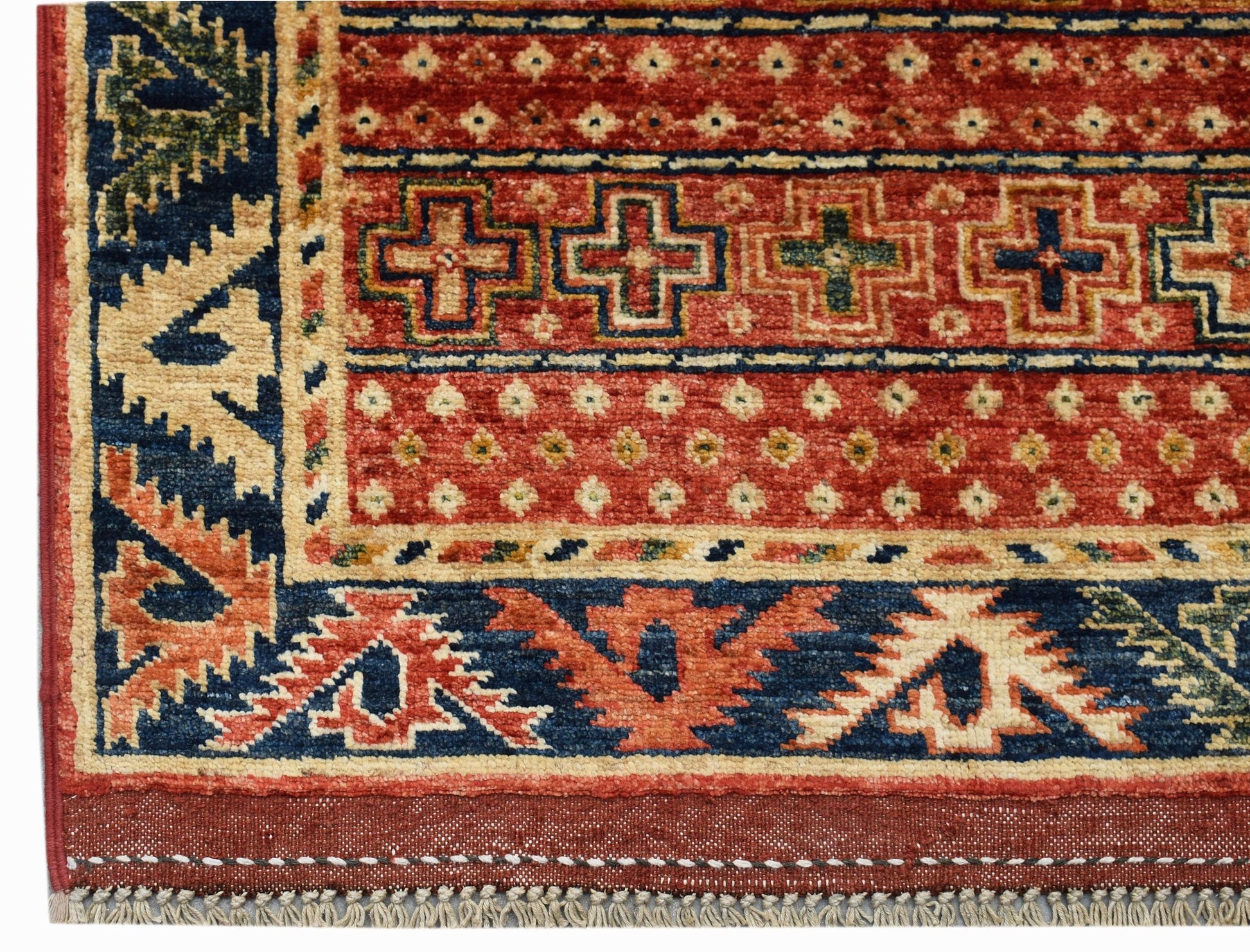 A handwoven Afghan Chobi runner featuring geometric patterns in red, blue, and cream wool.