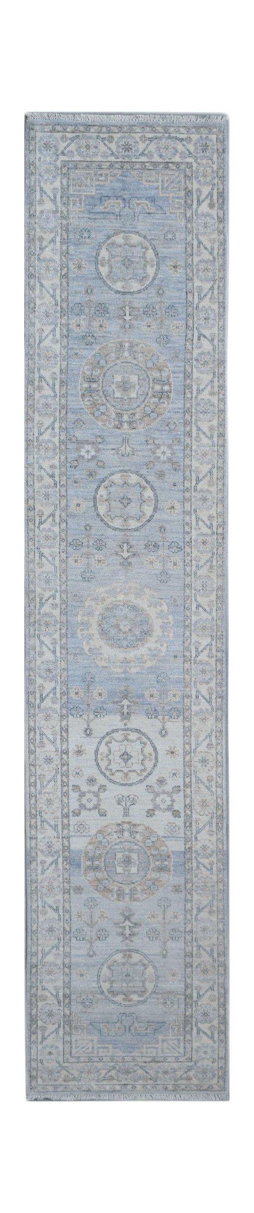 A handmade Afghan Chobi runner rug featuring traditional circular motifs in shades of blue and beige.