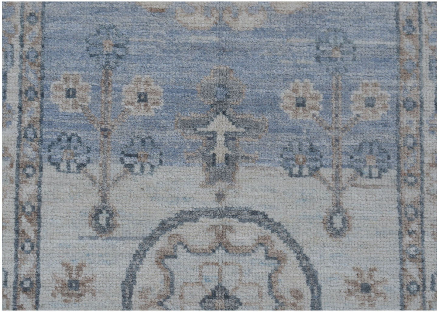 A handmade Afghan Chobi runner featuring traditional floral motifs in soft blue and beige tones.