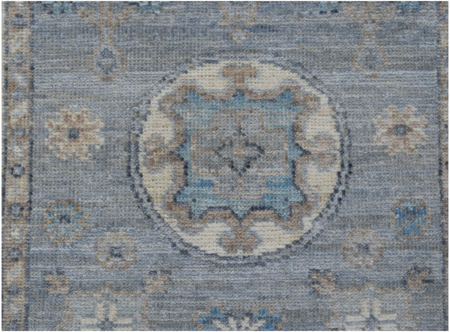 A handmade Afghan Chobi runner featuring a traditional blue and beige geometric medallion pattern.