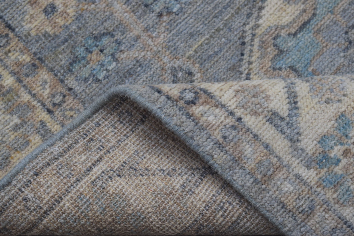A close-up of a handmade Afghan Chobi runner featuring a traditional pattern in blue and beige.