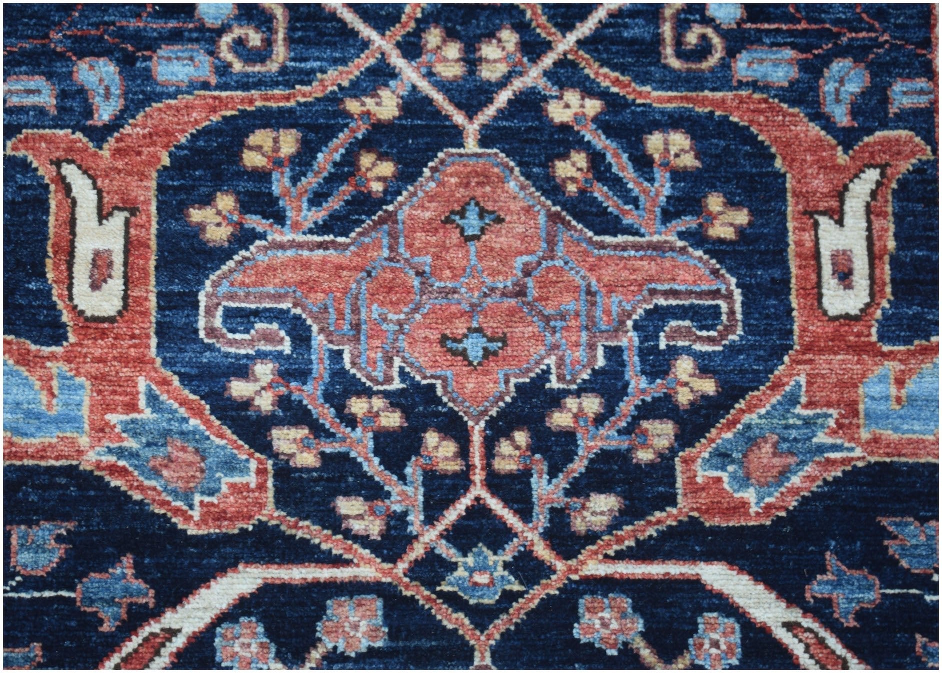 A close-up of an Afghan Chobi runner featuring a traditional floral pattern in blue and red tones.