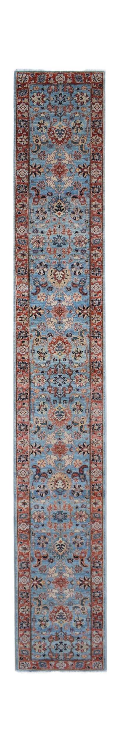 A handmade Afghan Chobi runner rug featuring a traditional floral pattern in blue and rust tones.