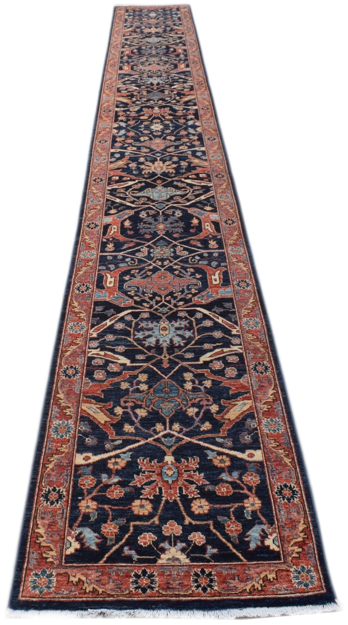 A long, handmade Afghan Chobi runner rug featuring a traditional floral pattern in earthy tones.