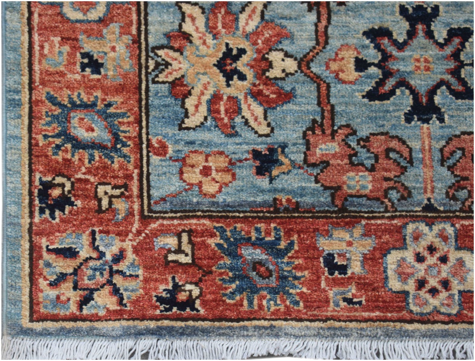 A handmade Afghan Chobi runner featuring traditional floral patterns in red and blue wool.
