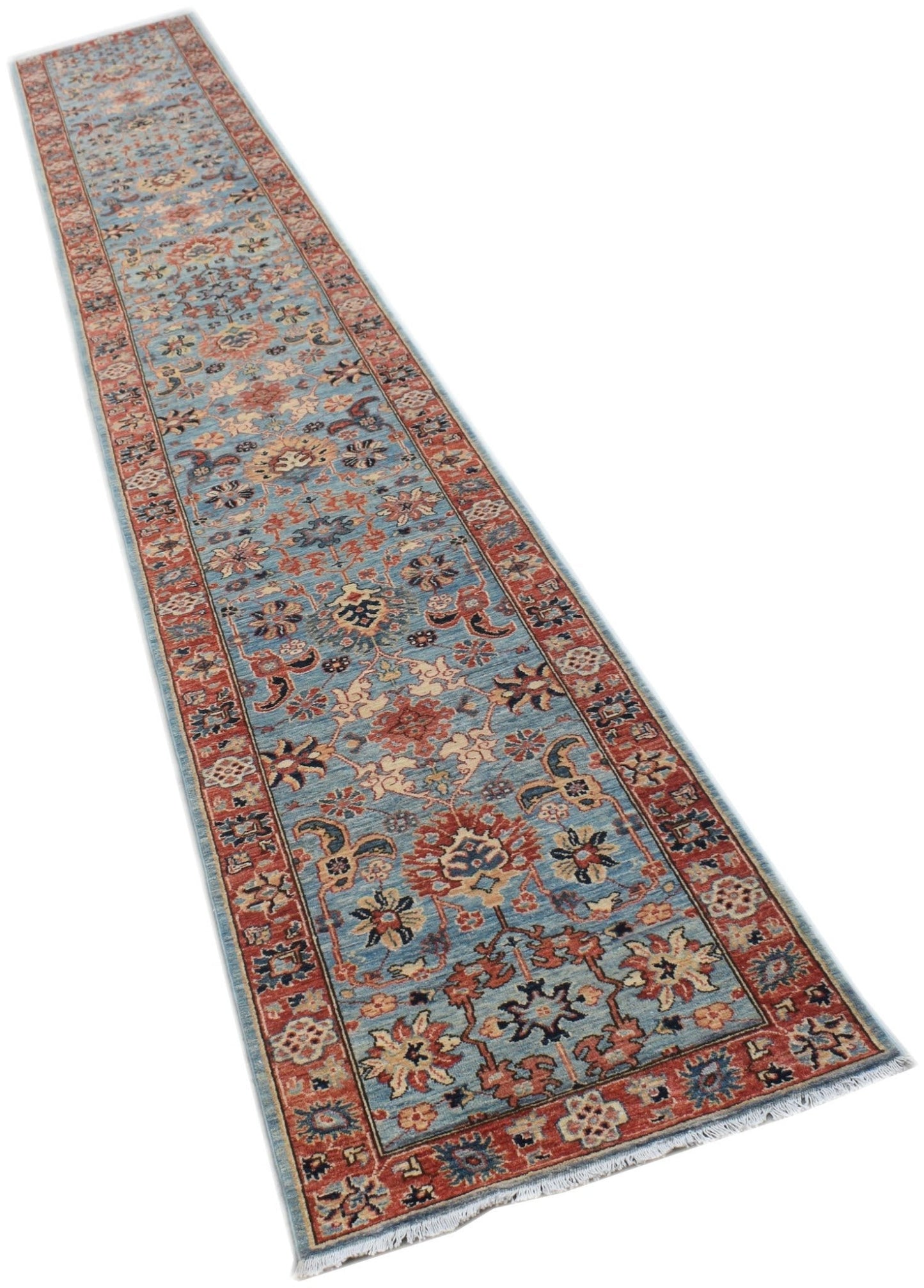 A long, handmade Afghan Chobi runner rug featuring a traditional floral pattern in blue and red.
