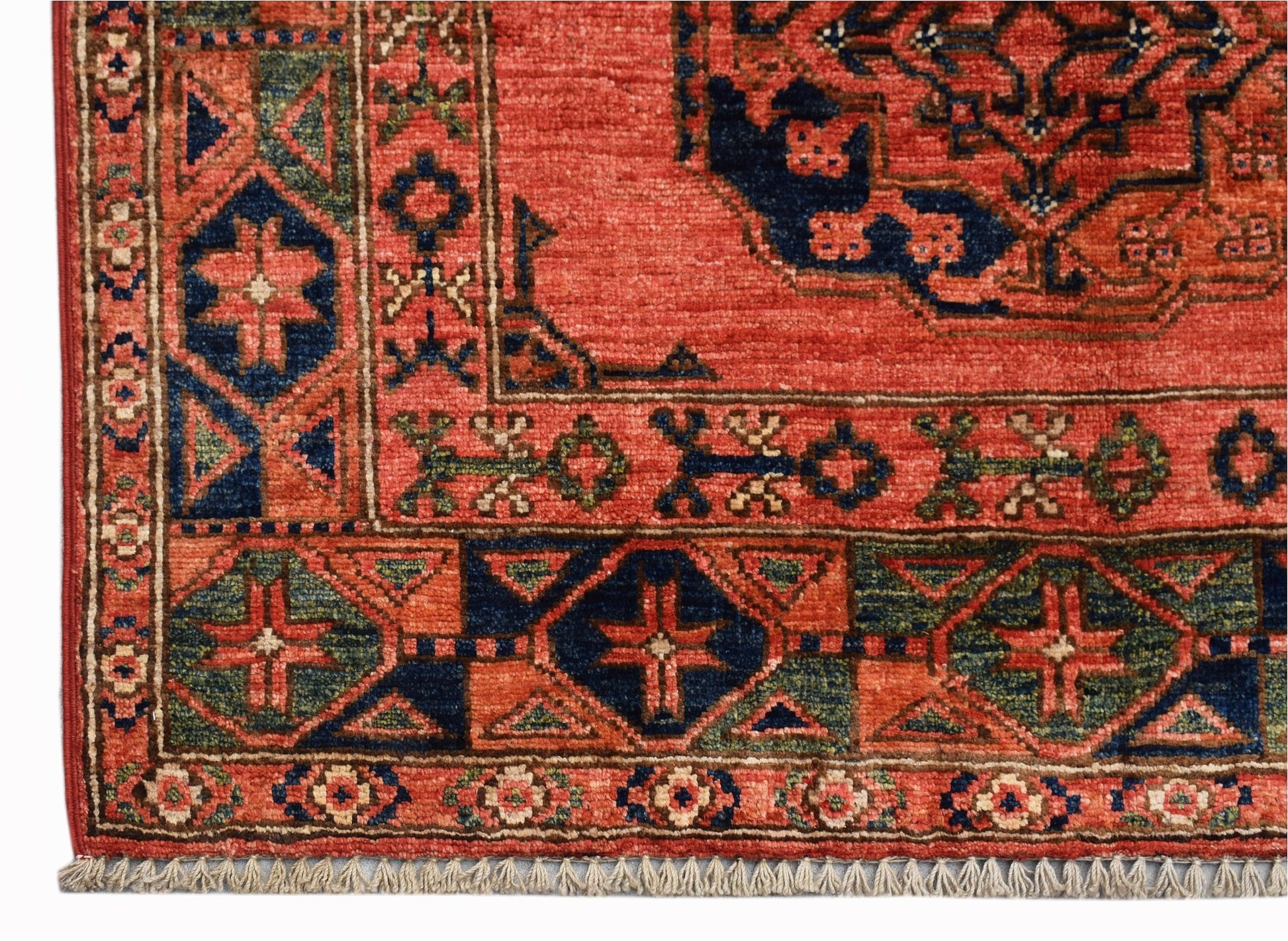 A handmade Afghan Chobi rug featuring traditional geometric patterns in red, blue, and green.
