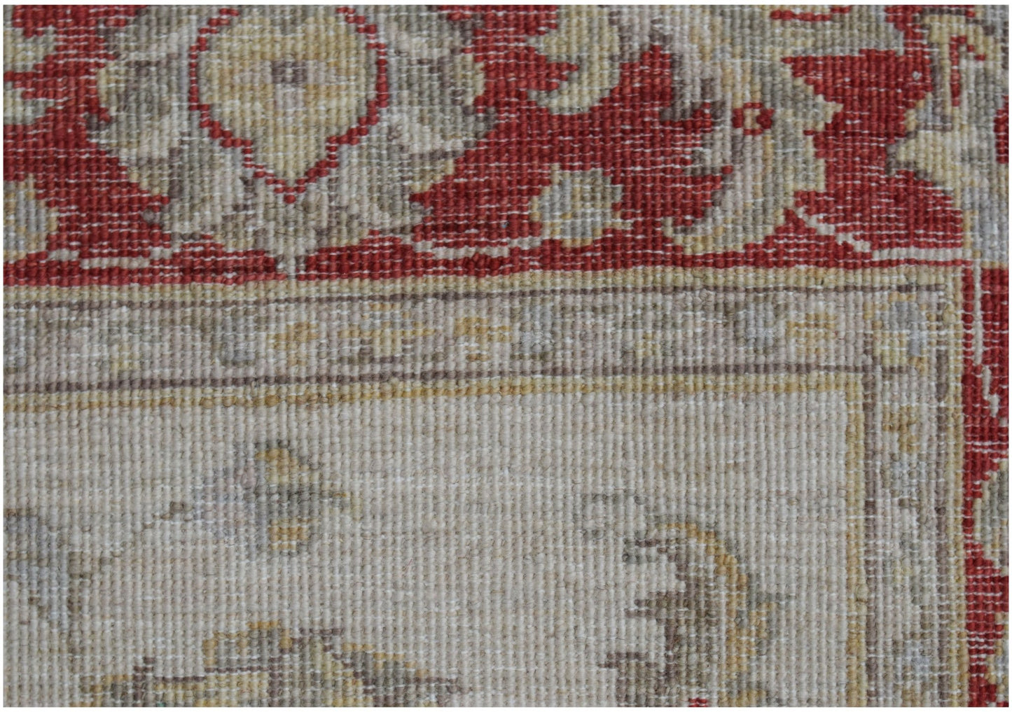 A close-up of a handwoven Afghan Chobi rug featuring a red floral border and a beige field.