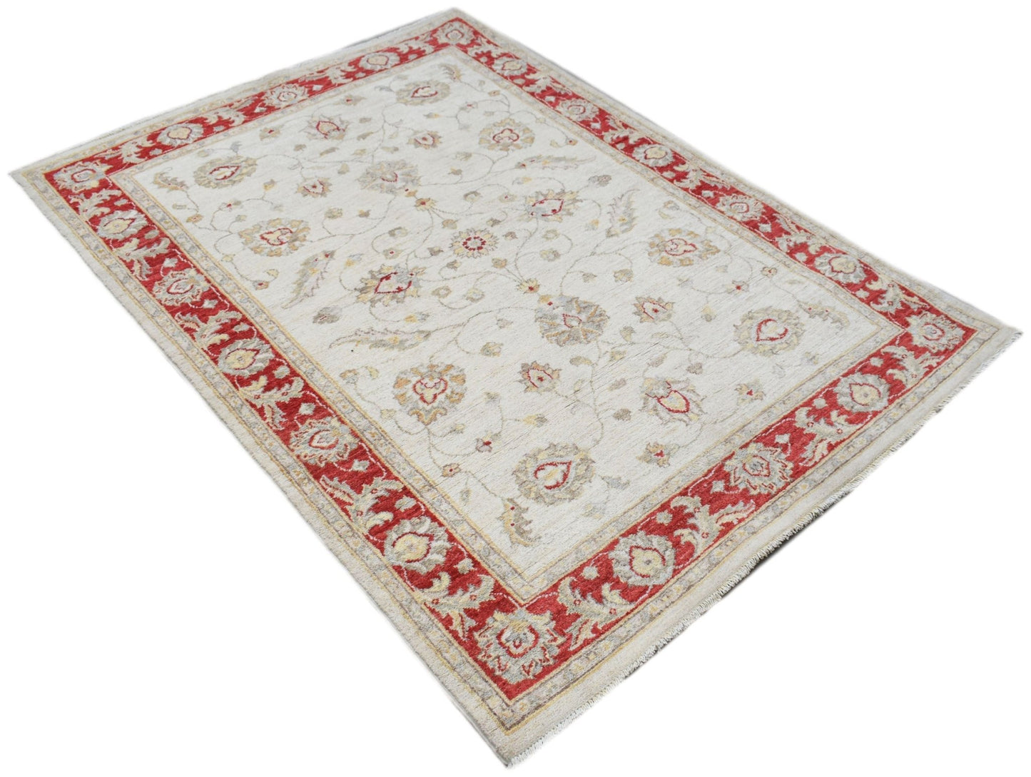 An Afghan Chobi rug featuring a cream field with floral motifs and a bold red border.