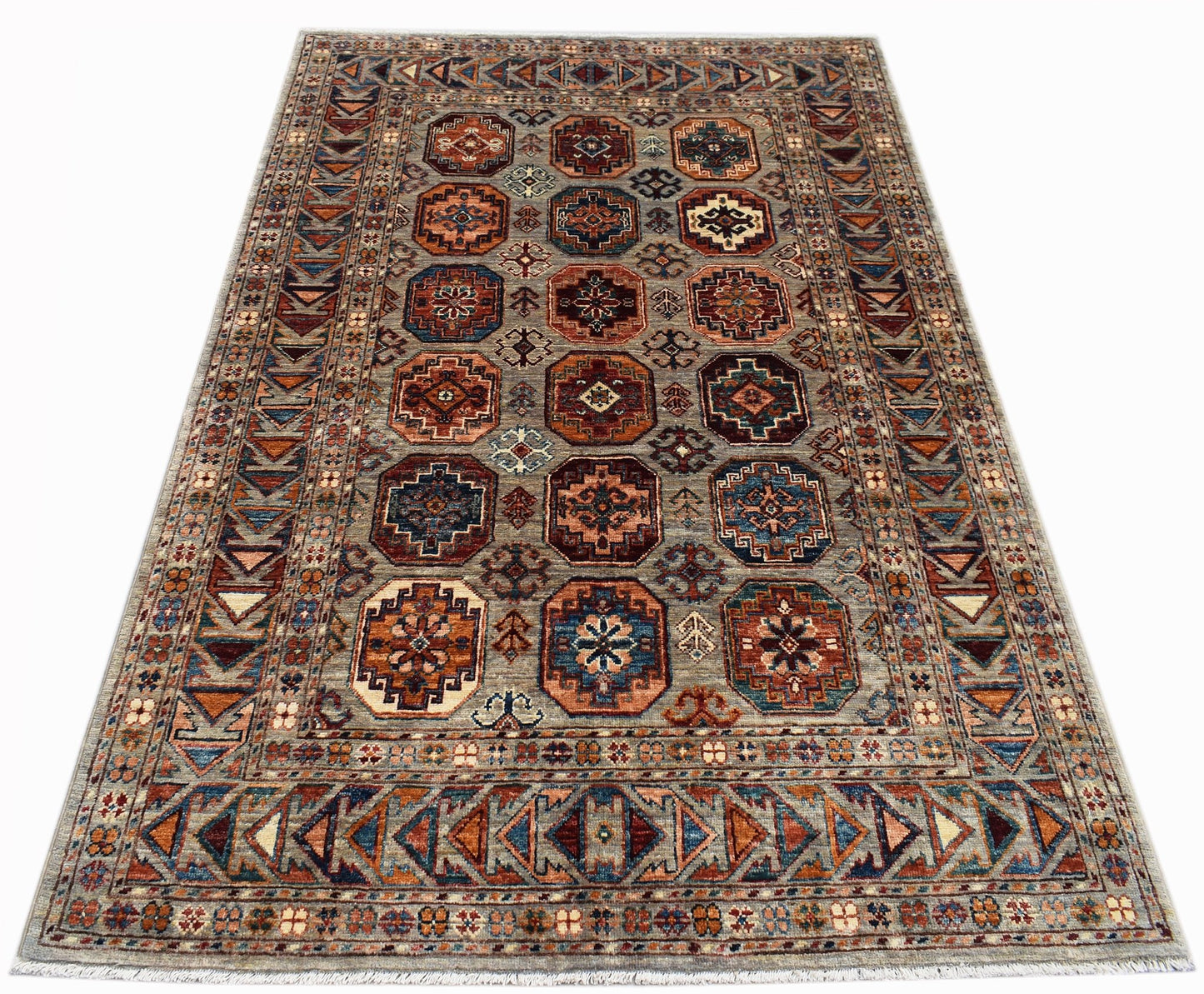 A rectangular Afghan Chobi rug featuring a geometric pattern of octagonal motifs in earthy tones.