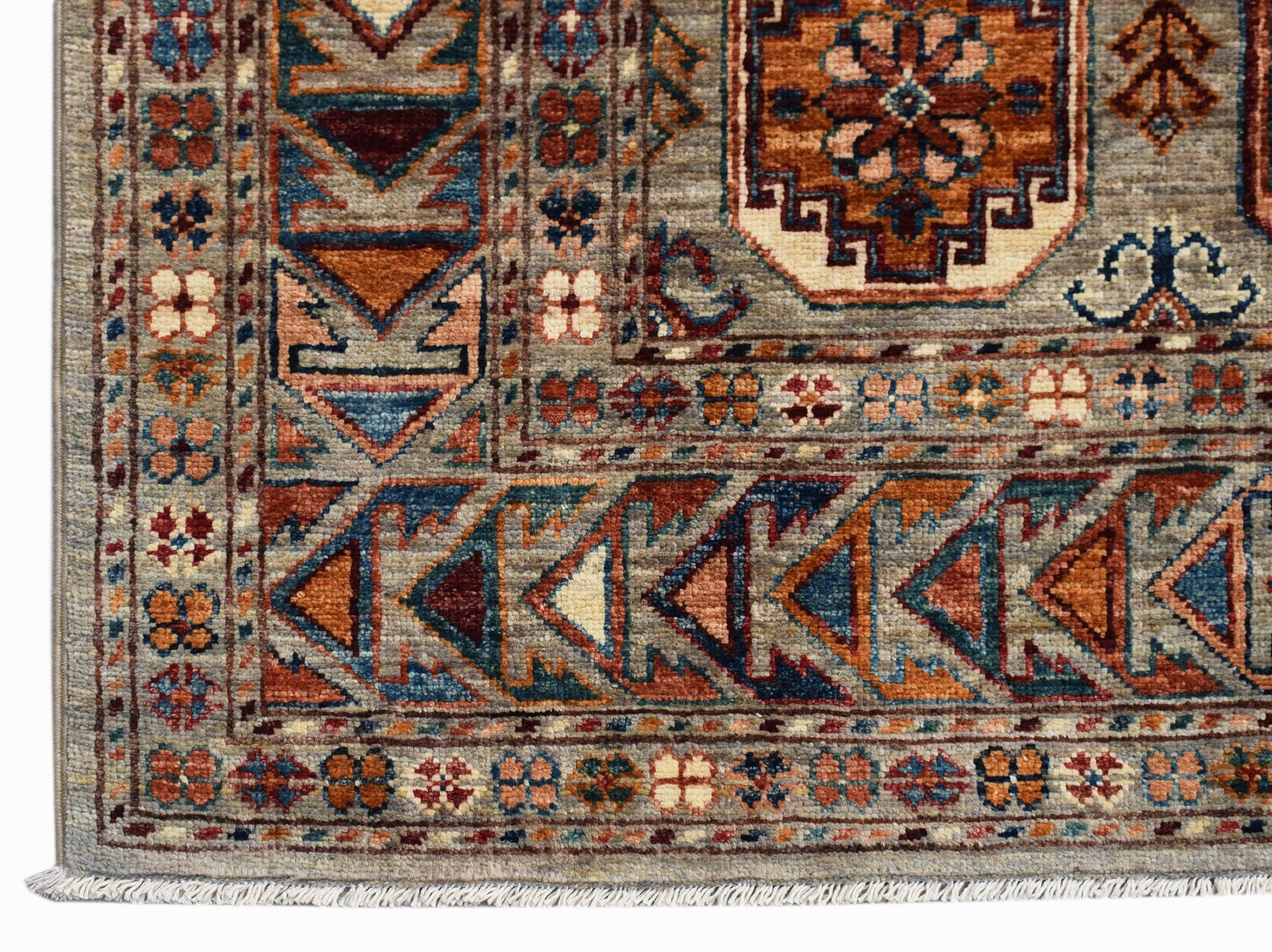 A handmade Afghan Chobi rug featuring intricate geometric patterns in earthy, wood-toned hues.