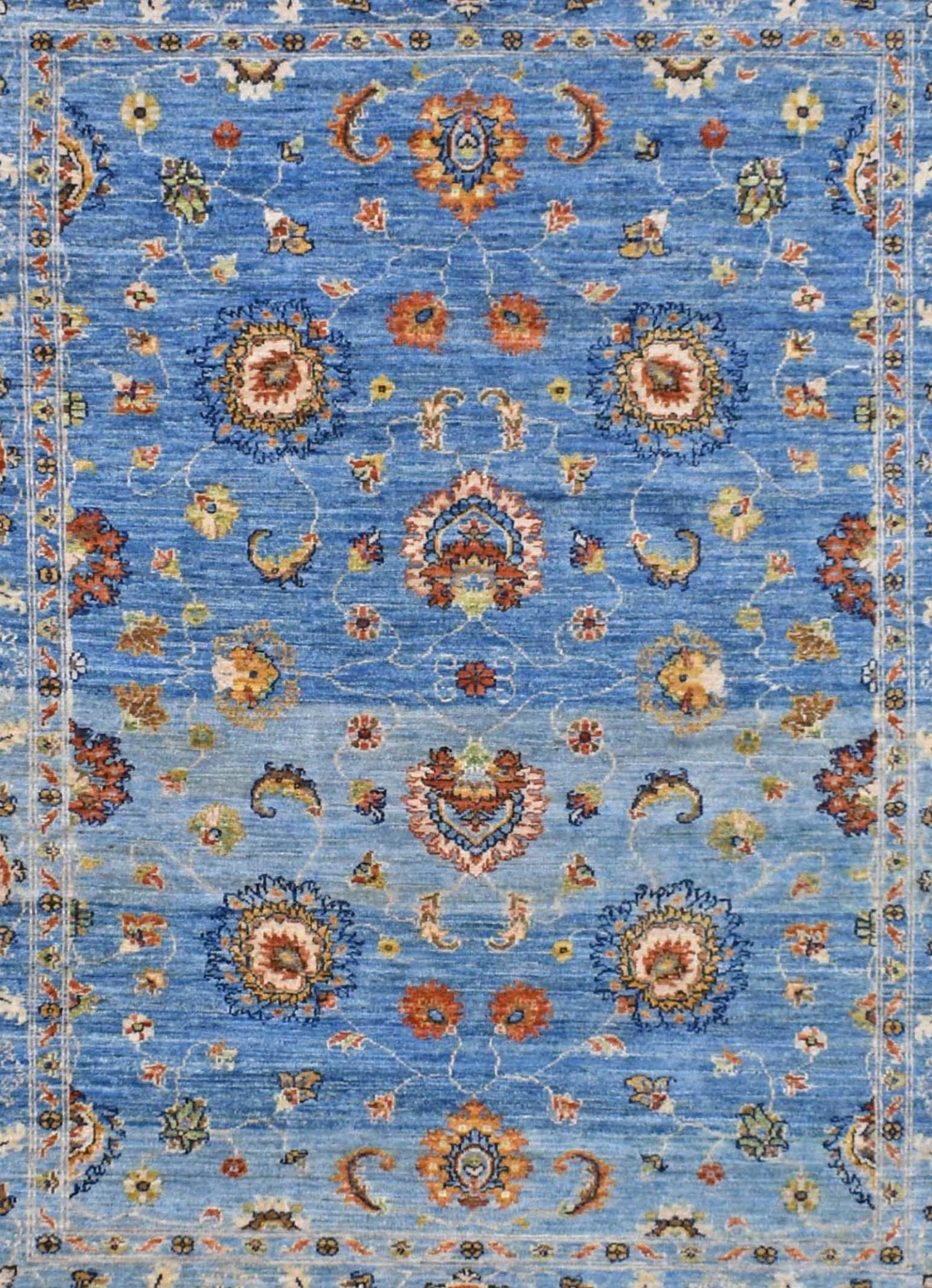 Handwoven Afghan Chobi rug featuring a traditional floral pattern in shades of blue and orange.