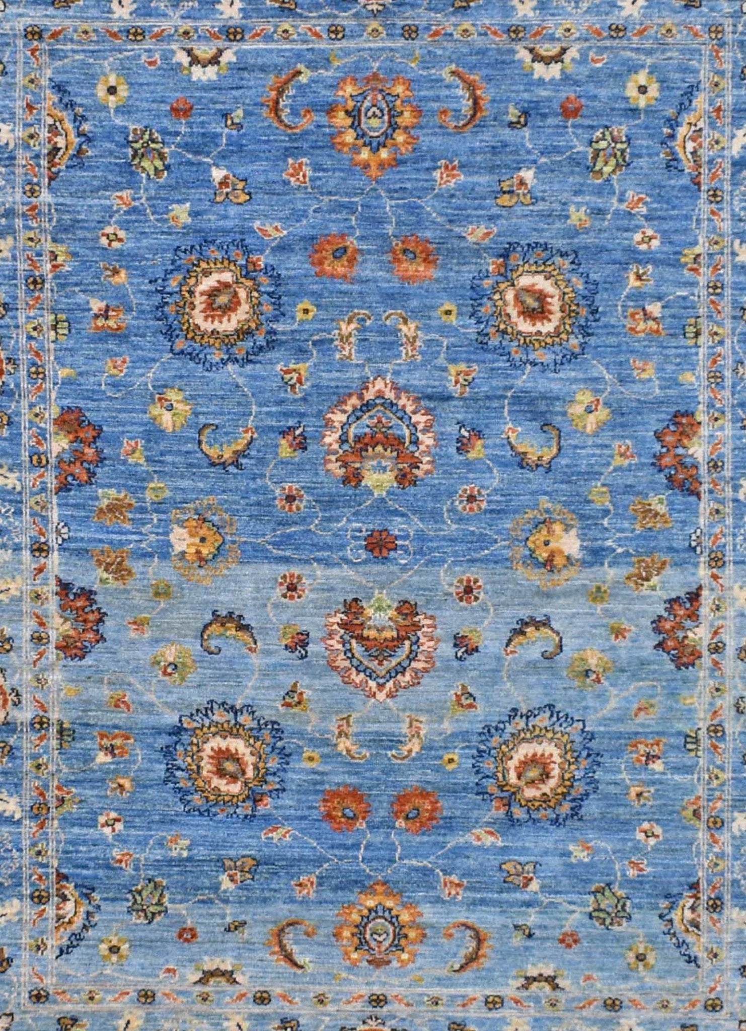 Handwoven Afghan Chobi rug featuring a traditional floral pattern in shades of blue and orange.