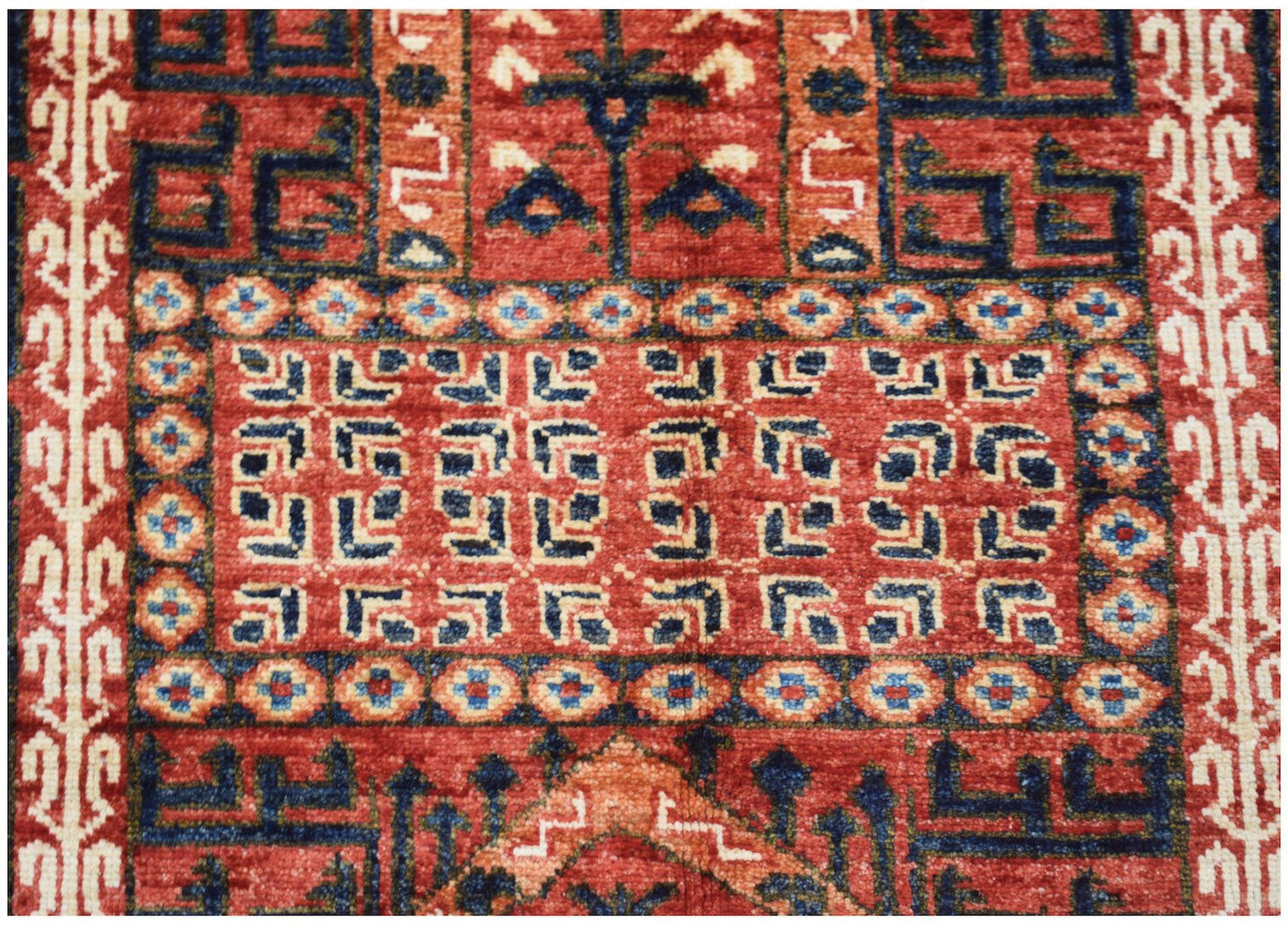 A handmade Afghan Chobi rug featuring intricate geometric patterns in shades of red and blue.