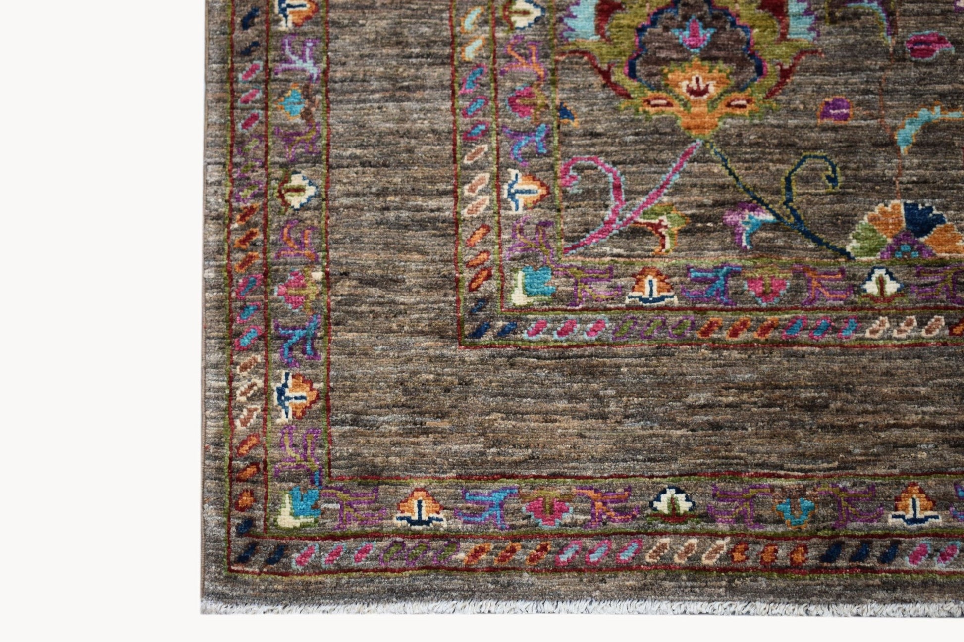 A handwoven Afghan Chobi rug featuring a brown textured field with colorful floral borders.