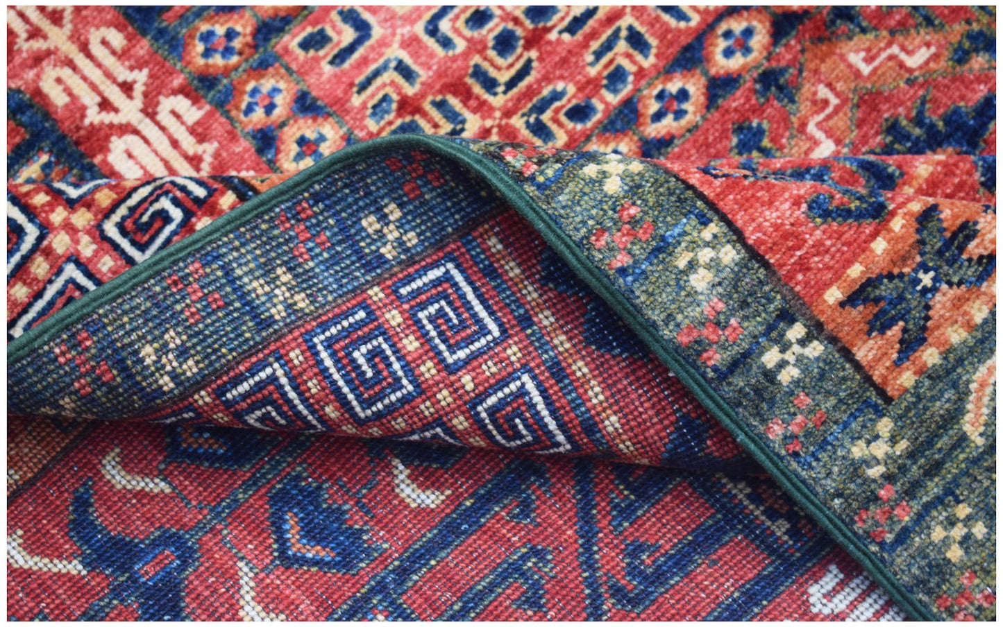 A handwoven Afghan Chobi rug featuring traditional geometric patterns in red, blue, and green.