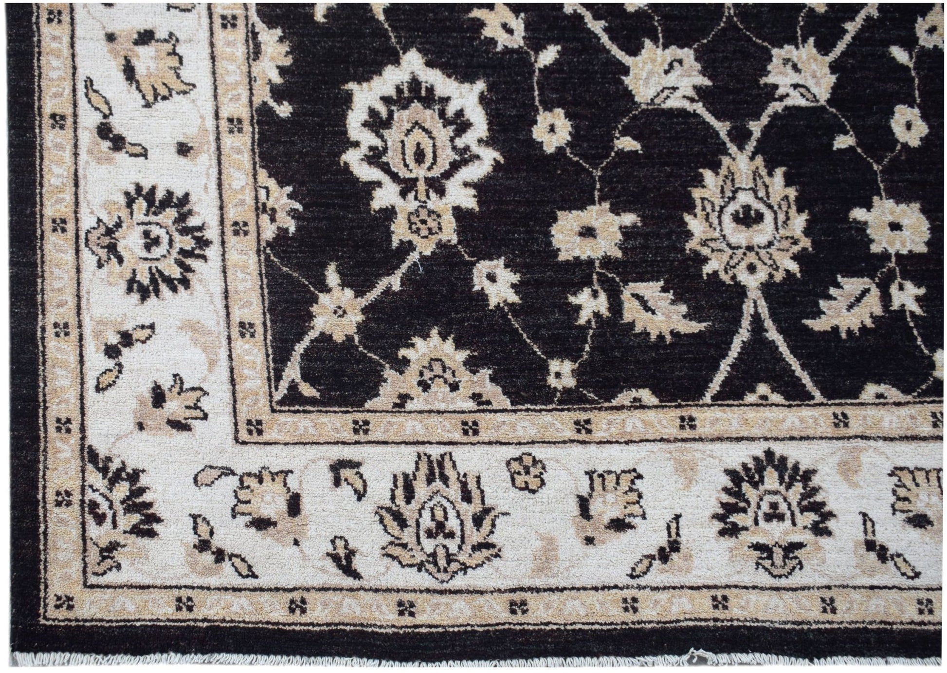 A handmade Afghan Chobi rug featuring a dark field with intricate floral patterns and a light border.