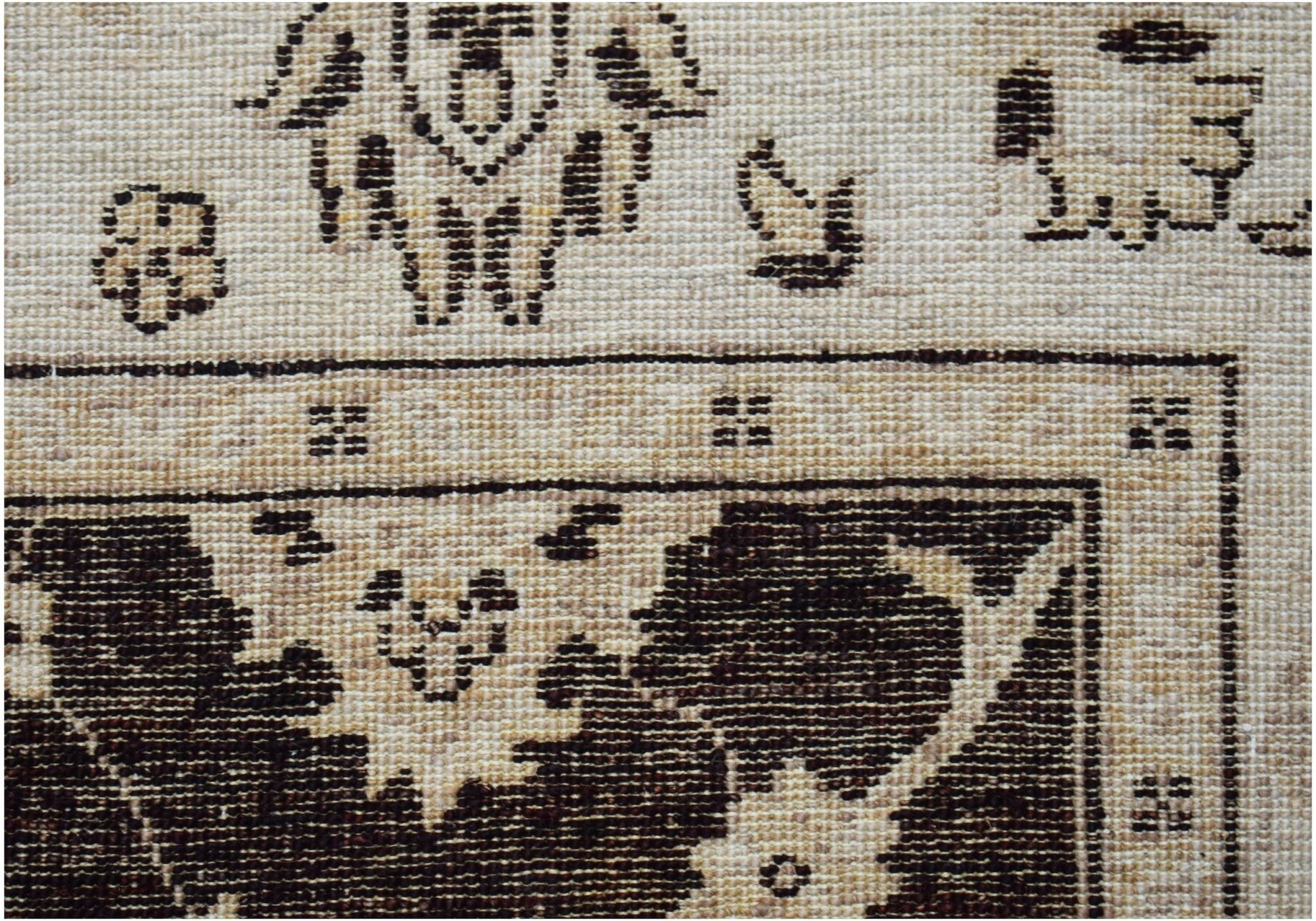 A close-up of a handwoven Afghan Chobi rug featuring traditional dark brown floral motifs.