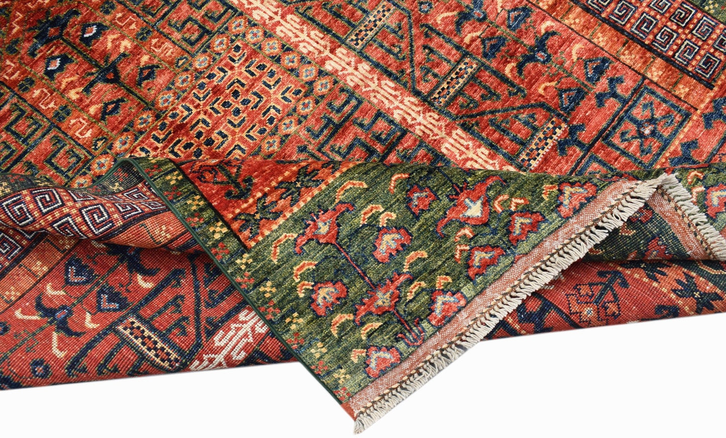 A handwoven Afghan Chobi rug featuring a geometric pattern in red, blue, and green wool.