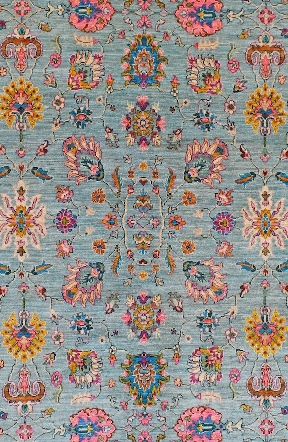 Handwoven Afghan Chobi rug featuring a traditional floral pattern in blue, pink, and gold tones.