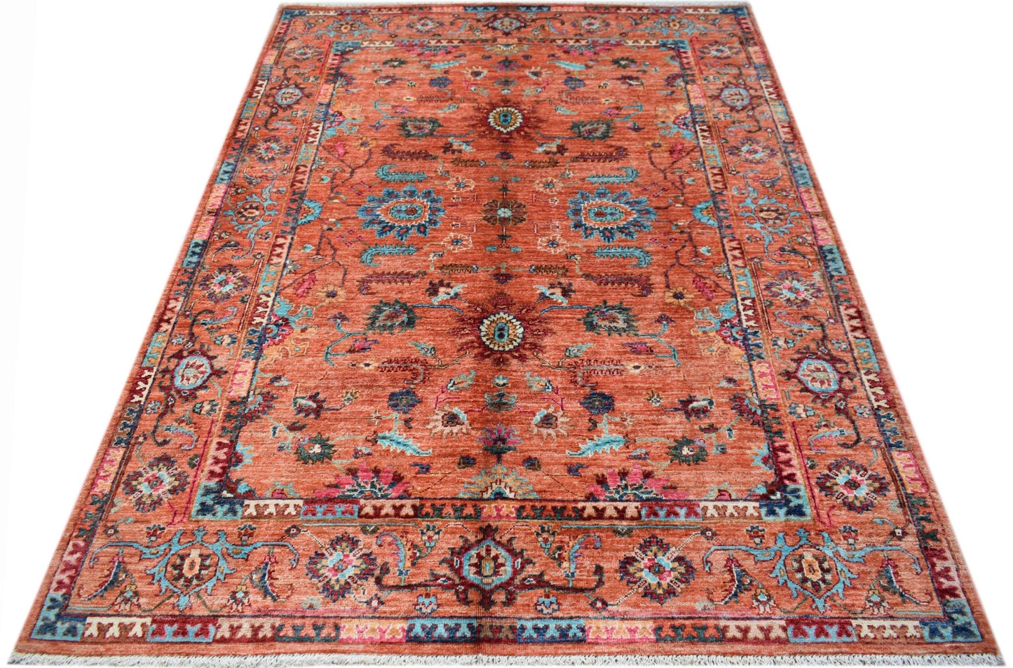 A rectangular Afghan Chobi rug featuring a traditional floral pattern in shades of orange and blue.