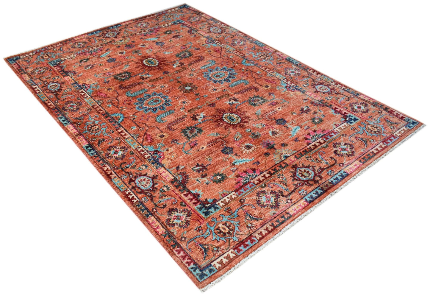 An Afghan Chobi rug featuring a traditional floral pattern in shades of rust, blue, and cream.