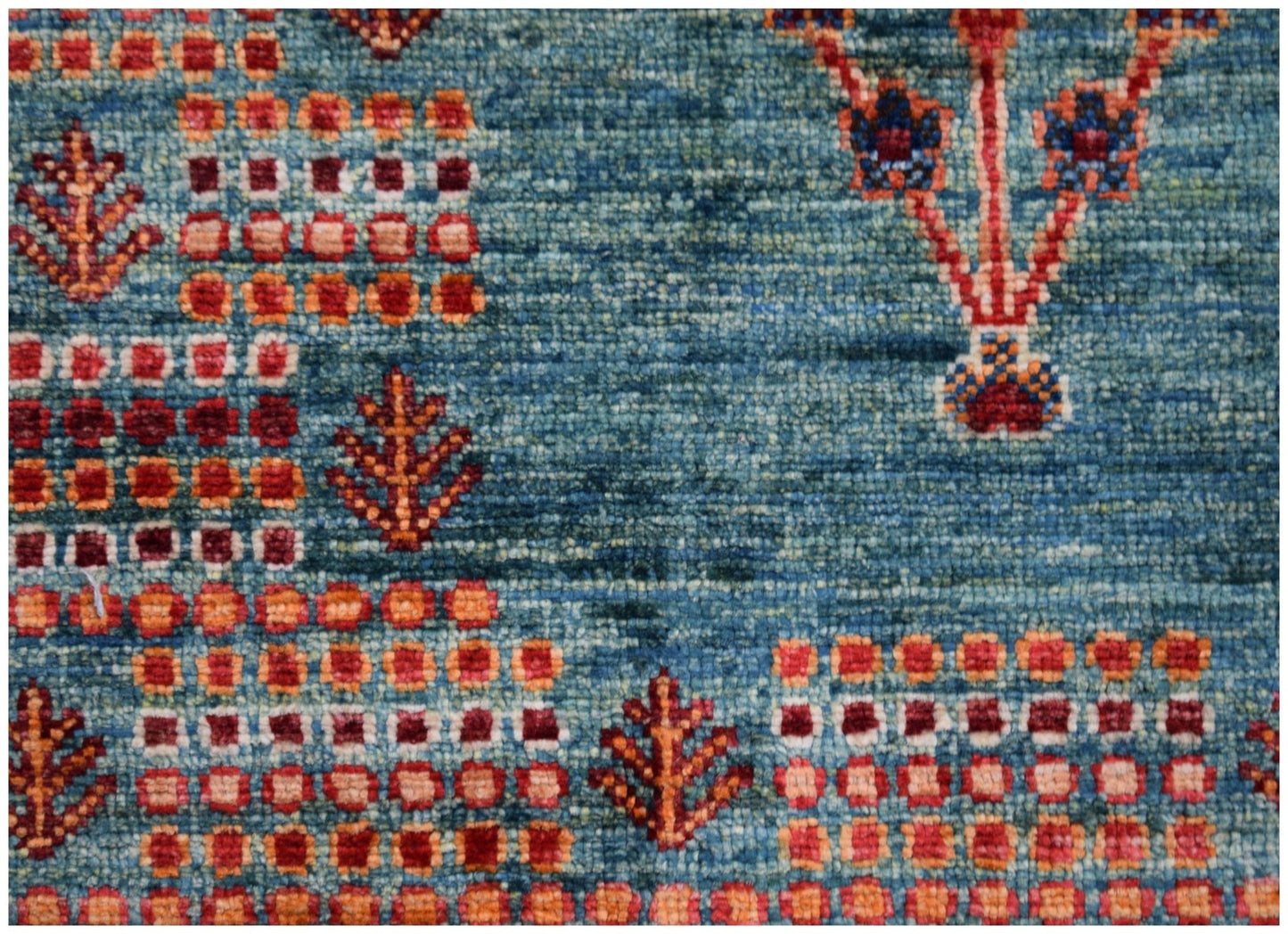 A handmade Afghan Chobi rug featuring a blue field with geometric patterns and floral motifs.