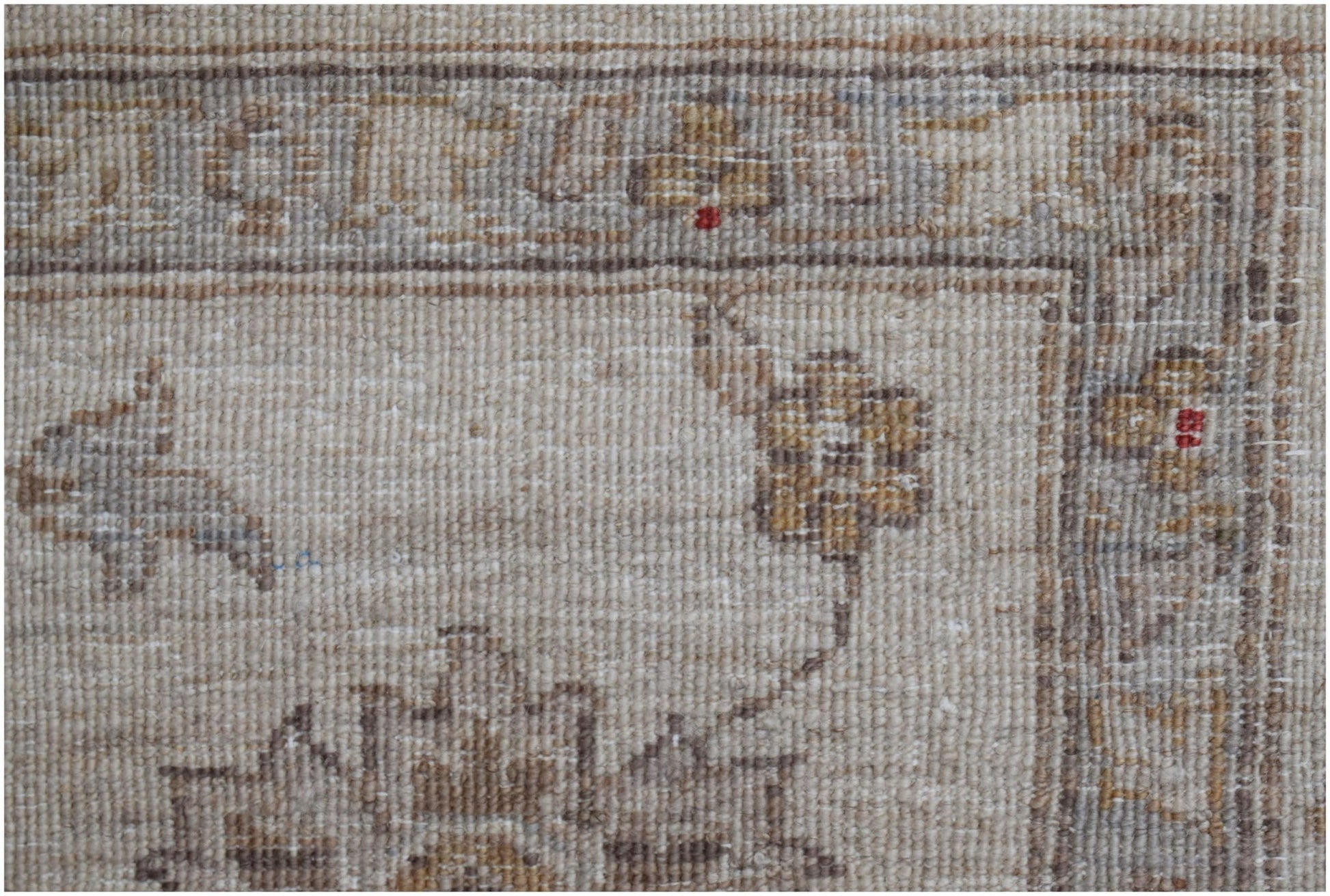 A close-up of a handwoven Afghan Chobi rug featuring traditional floral patterns in neutral tones.
