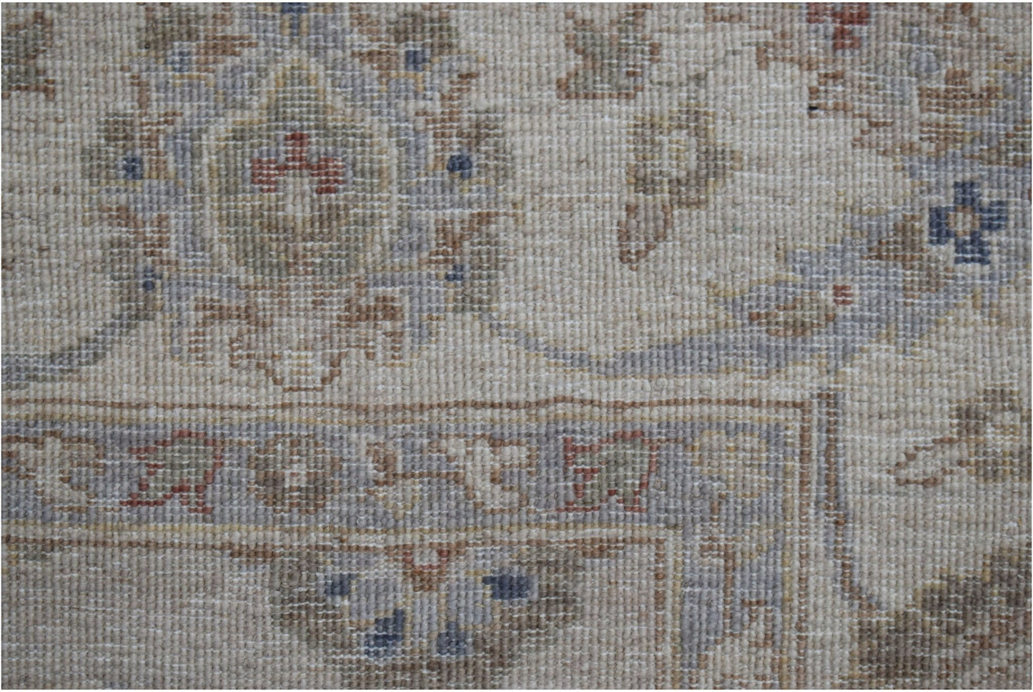 A close-up of a handwoven Afghan Chobi rug featuring traditional floral patterns in earthy tones.