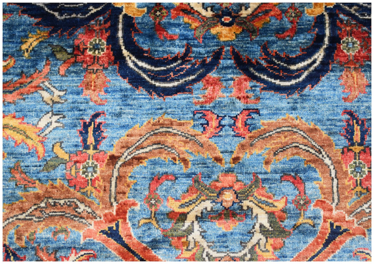 A handwoven Afghan Chobi rug featuring intricate floral patterns in blue, red, and earthy tones.