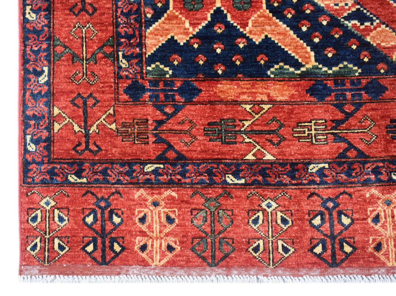 A handmade Afghan Chobi rug featuring traditional geometric patterns in red, blue, and cream tones.