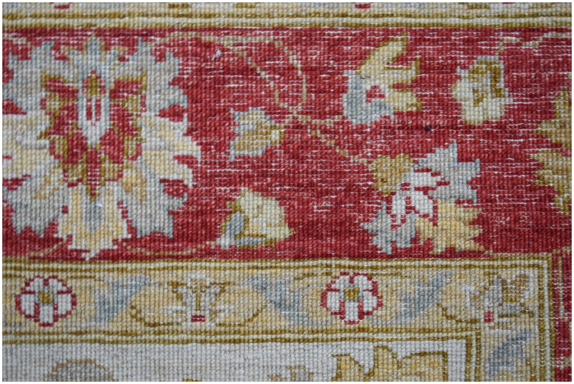 A close-up of a handwoven Afghan Chobi rug featuring traditional floral patterns in red and beige.