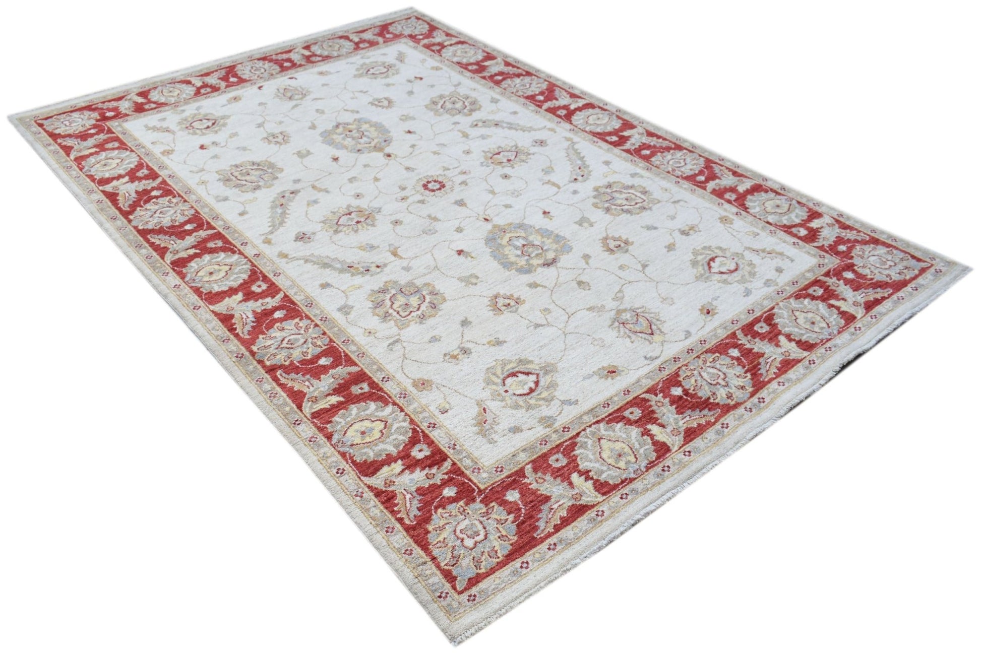 An Afghan Chobi rug featuring a cream field with floral patterns and a wide red border.
