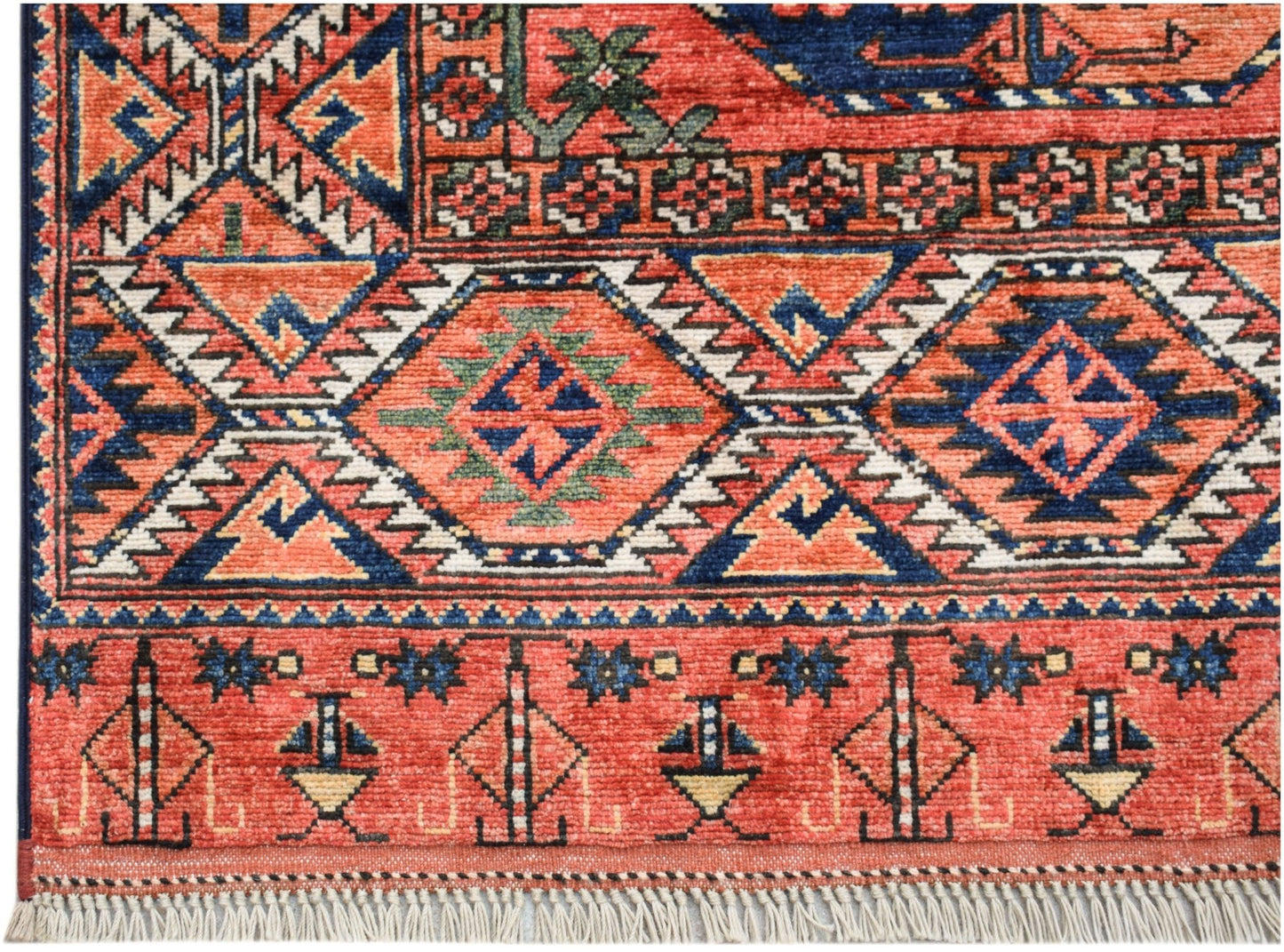 A handwoven Afghan Chobi rug featuring traditional geometric patterns in red, blue, and cream.