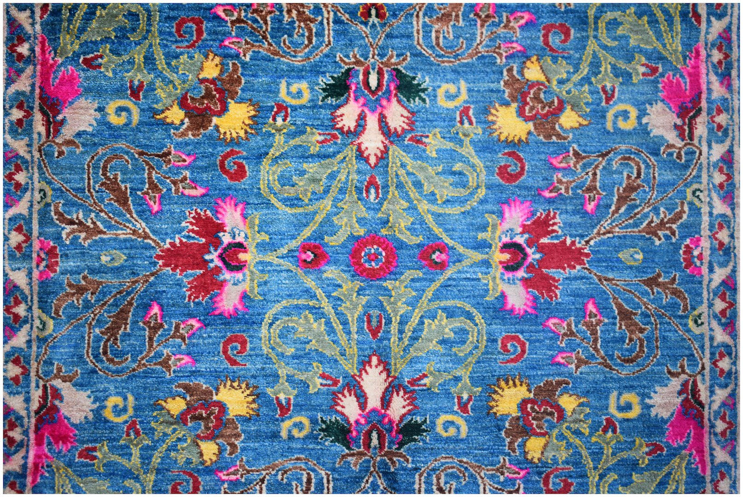 A handwoven Afghan Chobi rug featuring a vibrant blue field with intricate floral patterns.
