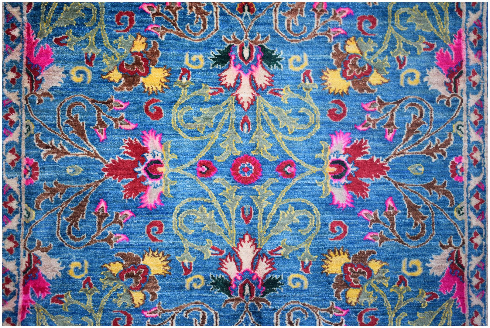 A handwoven Afghan Chobi rug featuring a vibrant blue field with intricate floral patterns.