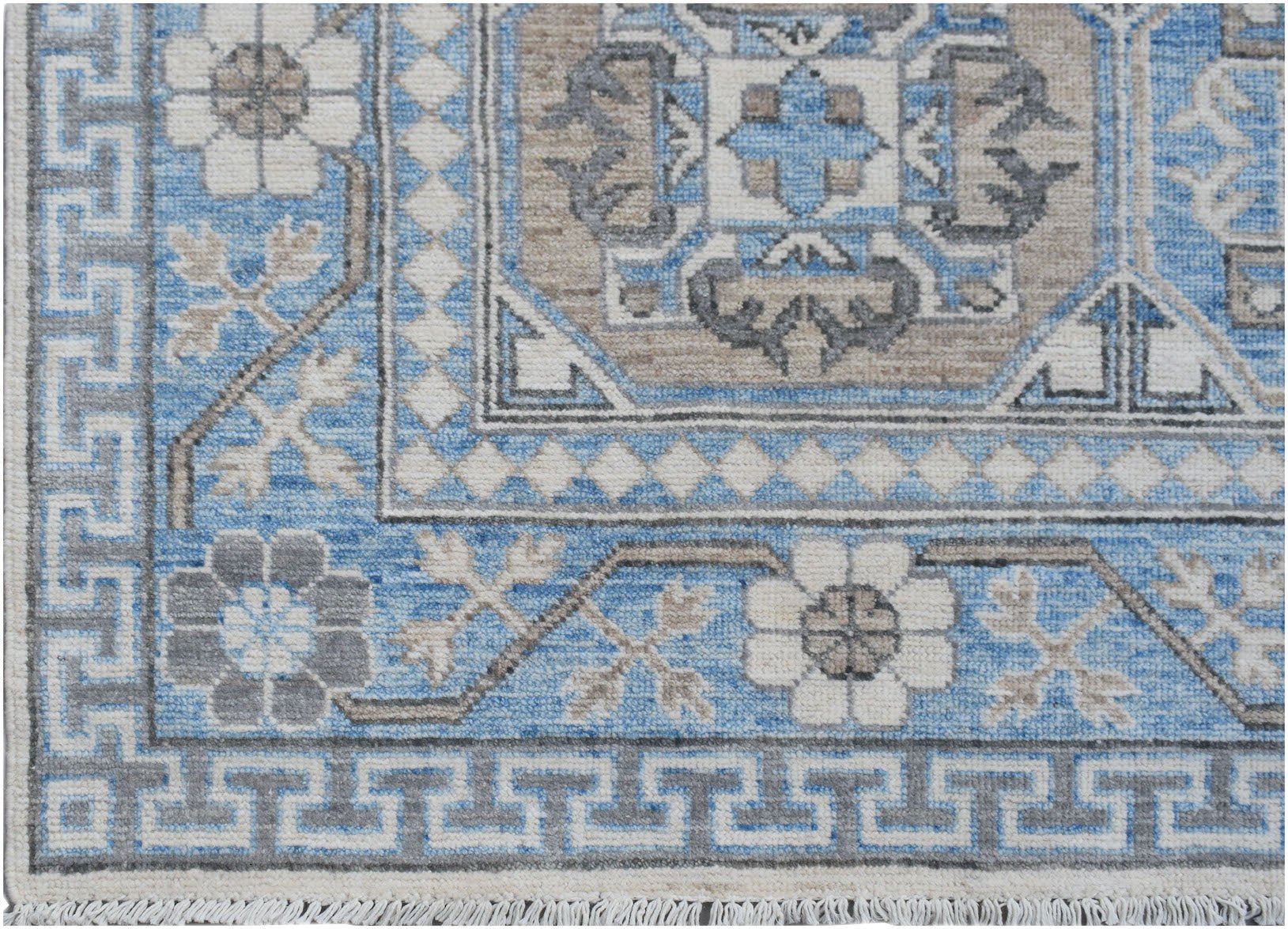 A handmade Afghan Chobi rug featuring a blue and beige geometric pattern with a Greek key border.
