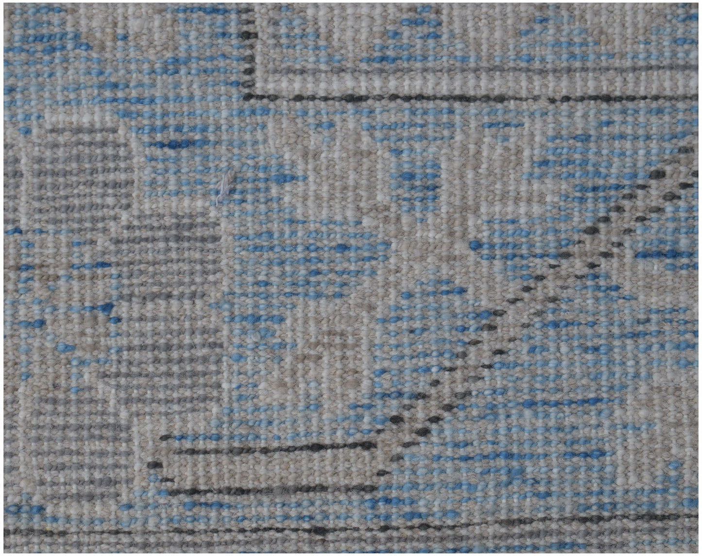 A close-up of a handmade Afghan Chobi rug featuring a textured pattern in blue, grey, and beige.