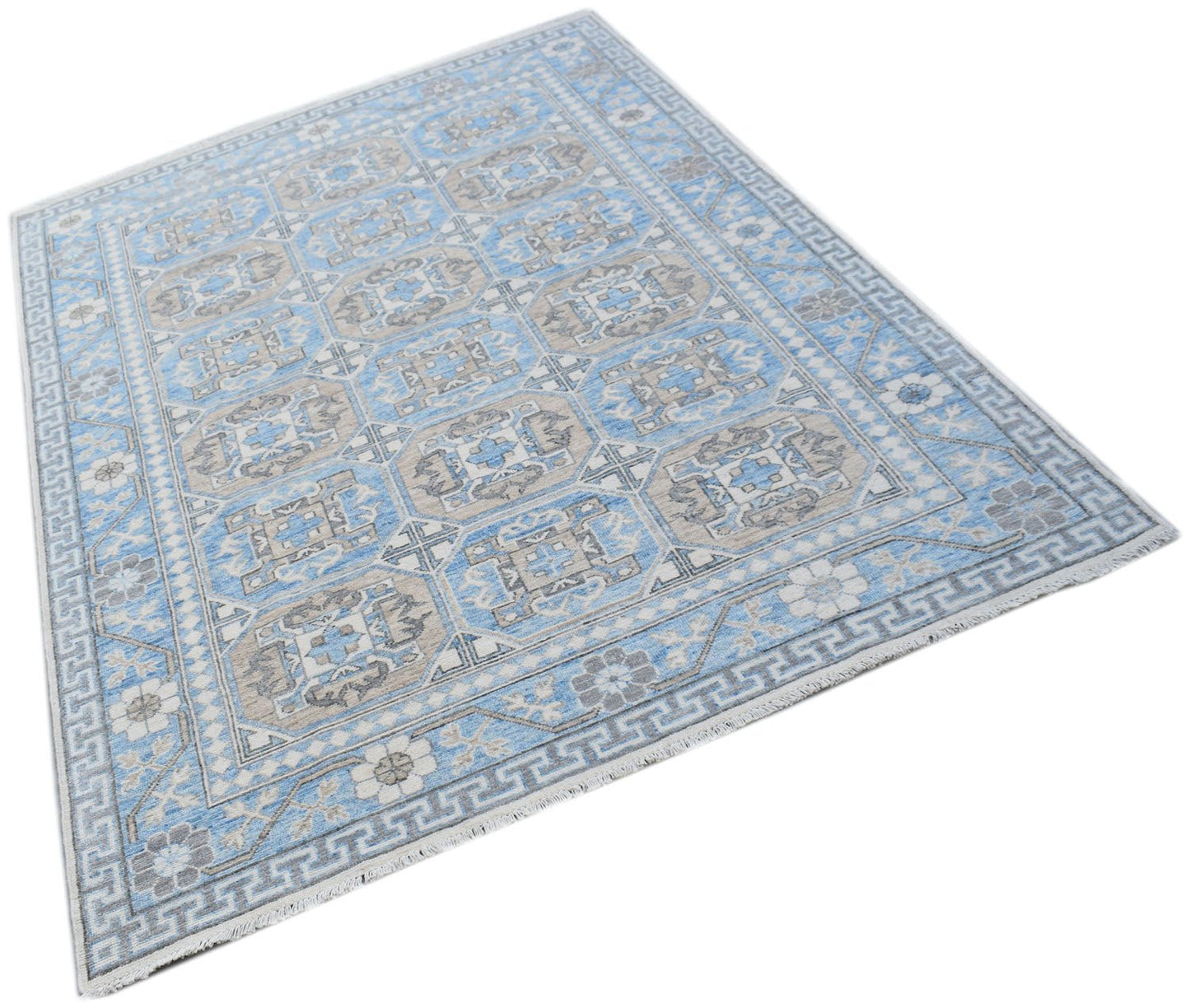 A handmade Afghan Chobi rug featuring a repeating geometric pattern in shades of blue and beige.