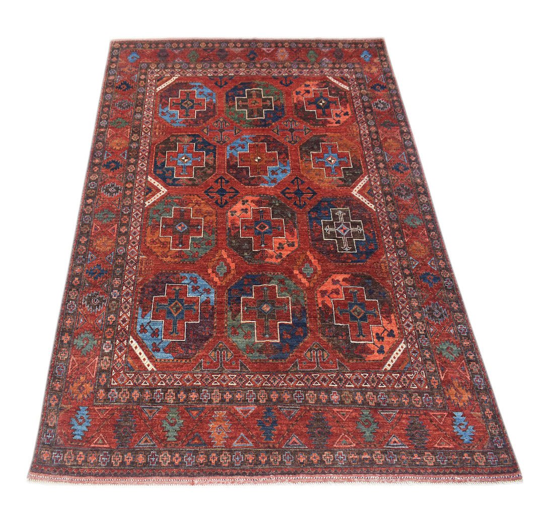 A handmade Afghan Chobi rug featuring a geometric pattern of octagons in shades of red and blue.