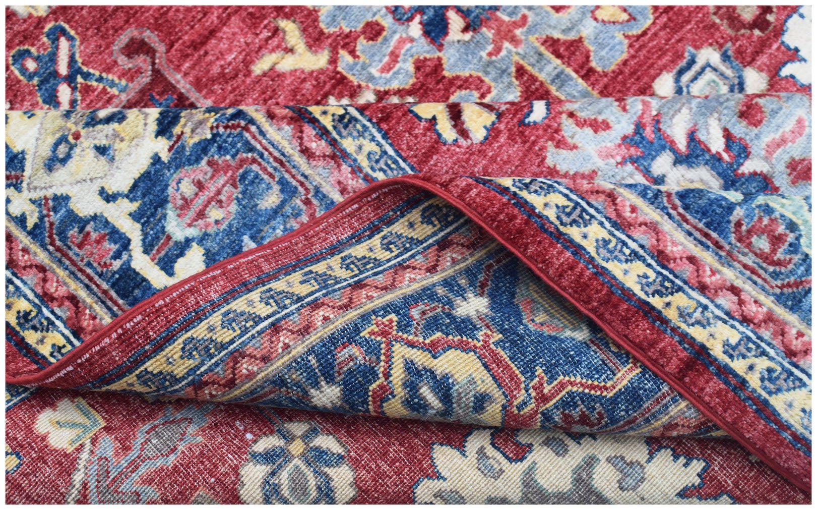A handmade Afghan Chobi rug featuring a traditional floral pattern in red, blue, and cream tones.