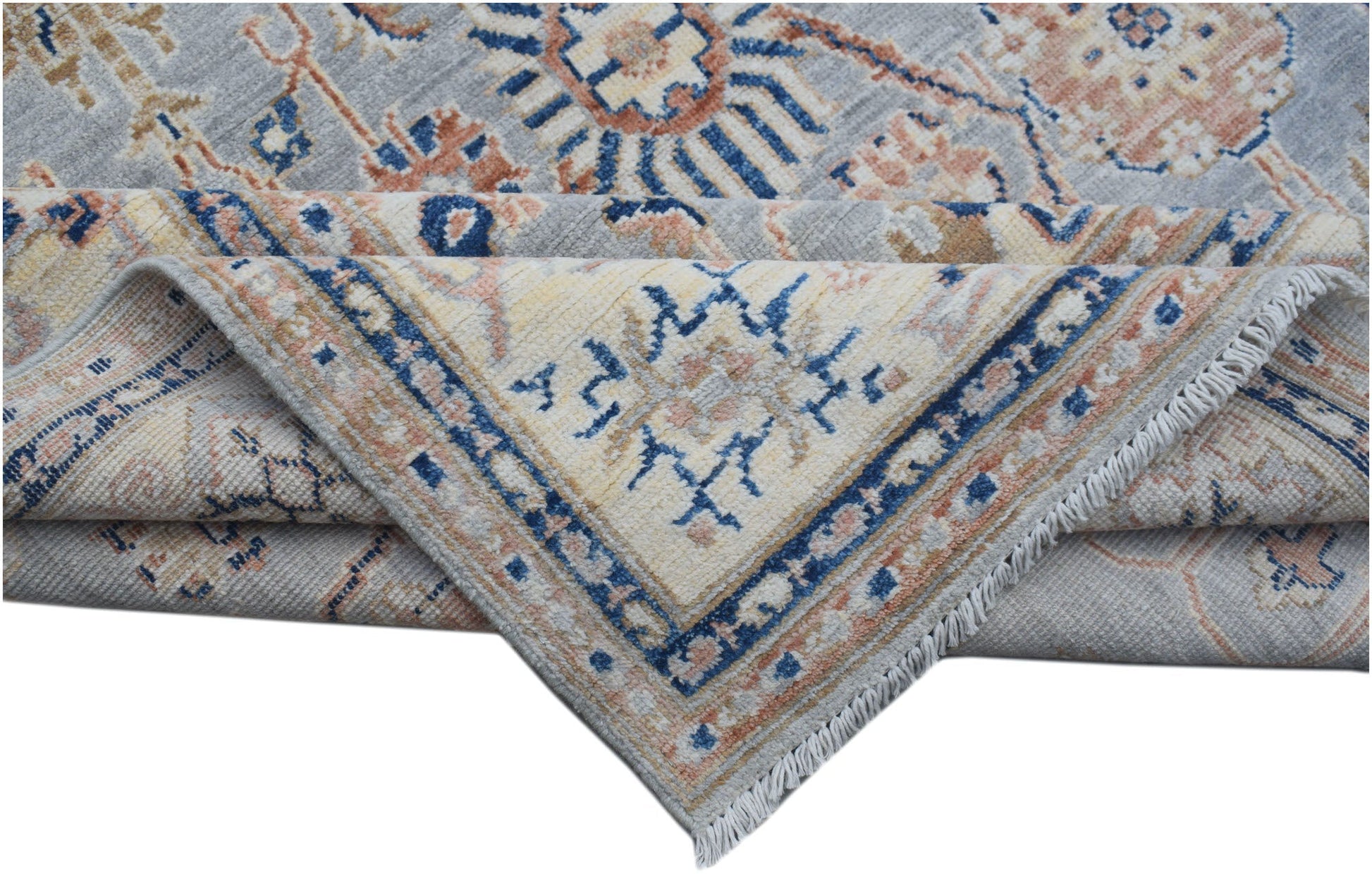 A folded Afghan Chobi rug featuring a traditional geometric pattern in blue, cream, and tan tones.
