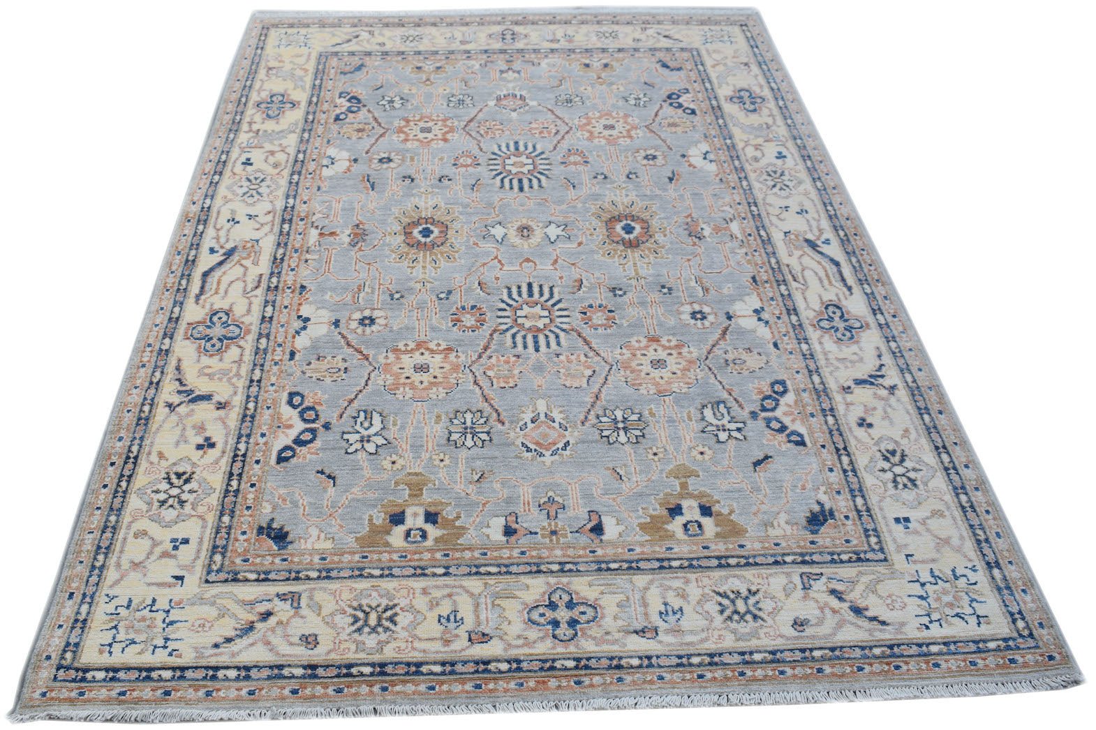 A handmade Afghan Chobi rug featuring a traditional floral pattern in soft blue and beige tones.