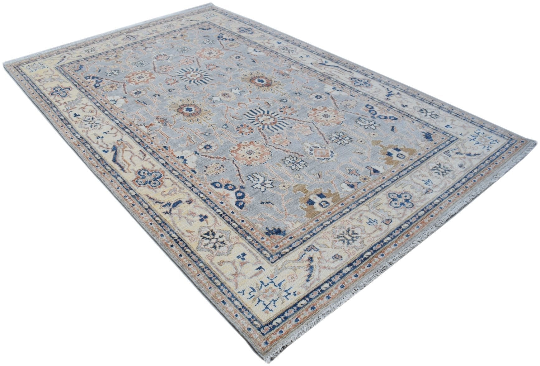 Handmade Afghan Chobi rug featuring a traditional floral pattern in soft blue and beige tones.
